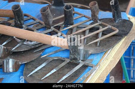 Un homme vend des outils de jardinage et l'agriculture Banque D'Images