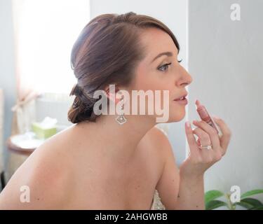 Woman putting on lipstick. Banque D'Images