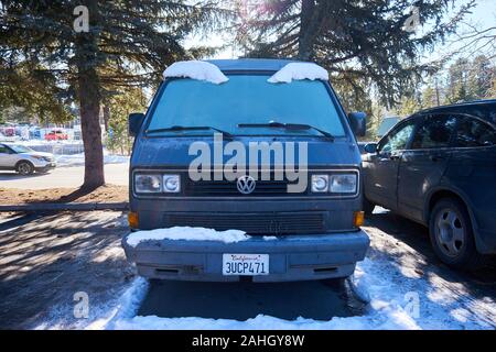 L'avant d'un van VW classique avec de la neige sur le pare-brise qui ressemble à sourcils parqué dans un lot en hiver à Truckee, Californie, USA. Banque D'Images