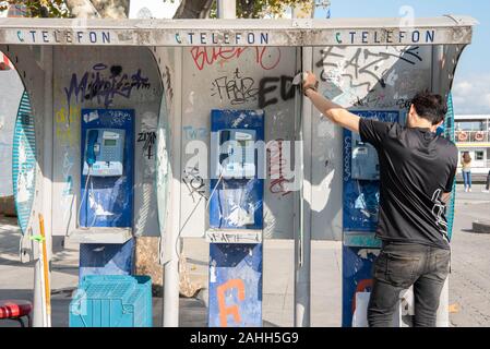 Un jeune homme à l'aide de téléphone public à la fois en Street Banque D'Images