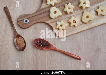 Mise à plat des cookies sur planche à découper en bois et des cuillères en bois avec des épices Banque D'Images