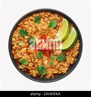 Keema poulet en noir bol isolée à fond blanc. Kheema est la cuisine indienne et pakistanaise curry plat avec la viande hachée et les épices. Banque D'Images