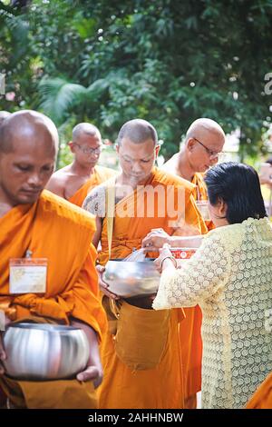 Phuket - Thaïlande, 7 mai 2019 : Beaucoup de Thai moine avec bol d'aumône vieille dame tout en proposant des aliments mis dans le bol, faire un bain de fumée d'un débit jusqu'à l'heure du matin Banque D'Images