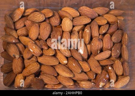 Pile d'amandes dans la boîte en plastique Banque D'Images