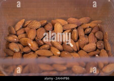 Pile d'amandes dans la boîte en plastique Banque D'Images