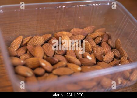 Pile d'amandes dans la boîte en plastique Banque D'Images