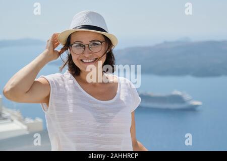 Portrait de femme d'âge moyen voyageant sur croisière de luxe en Méditerranée. Female looking at camera sur l'île de Santorin, copy space Banque D'Images