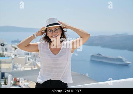 Portrait de femme d'âge moyen voyageant sur croisière de luxe en Méditerranée. Female looking at camera sur l'île de Santorin, copy space Banque D'Images