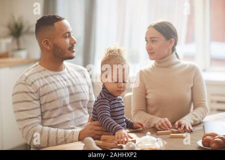 Portrait chaleureux de race mixte moderne à la famille à l'autre tout en jouant avec sa fille mignon à la maison Banque D'Images