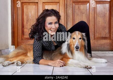 femme portant une chemise noire assise avec son chien Banque D'Images