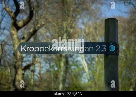 Un chemin dans le parc national suédois appelé Dalby Söderskog. Il affiche le nom du chemin et combien de temps il est en kilomètres. Banque D'Images