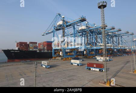 Les conteneurs de transport camions conteneurs déchargés d'un navire sur un quai à Lianyungang port de Lianyungang Ville, Province de Jiangsu est o Banque D'Images