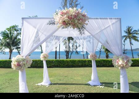 Paramètre de passage weddding piscine avec ciel bleu et plage derrière, décorer avec un tissu blanc et simple fleur sur elle Banque D'Images