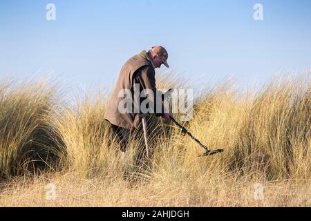 Southport, Merseyside, 30 décembre 2019. Un metal detectorist chasse les trésors cachés sur les dunes de sable de la plage de Southport Merseyside. Un soleil brillant et ciel bleu ont accueilli les visiteurs de la station balnéaire comme la douceur de l'hiver continue tout au long de la période des fêtes. Credit : Cernan Elias/Alamy Live News Banque D'Images