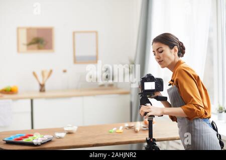 Taille portrait de belle jeune femme la mise en place de caméra pendant le tournage en studio tutoriel de cuisson, copy space Banque D'Images