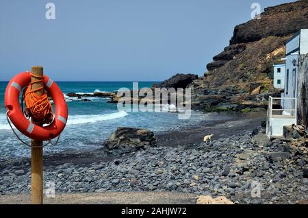 L'Espagne, l'île des Canaries, Fuerteventura, maisons et bouée de sauvetage sur plage dans village El Puerte de Los Molinos, Banque D'Images