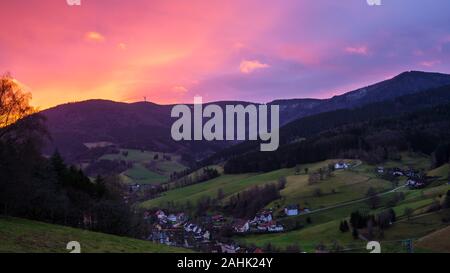 Allemagne, Red sky magique sur les montagnes et la vallée de la forêt-noire environnante village tôt le matin en hiver Banque D'Images