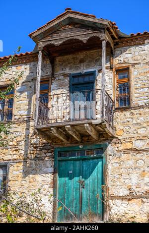 Balcon en bois sur une ancienne, traditionnelle, maison en pierre dans le village de pêcheurs sur le lac Prespa Psarades étonnant avec de la Macédoine, la Grèce du Nord. Banque D'Images