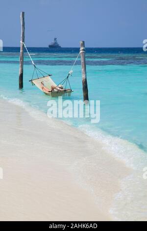 Femme portant un bikini et un chapeau, de détente dans un hamac dans la mer à Bandos Island, Maldives, océan Indien Banque D'Images