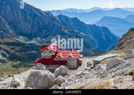 Avec les sacs à dos de randonnée touristique en montagne randonnée sur journée d'été. Homme randonnée dans les beaux paysages de montagne. Grimpeur et chalet de montagne à Dolomites Banque D'Images