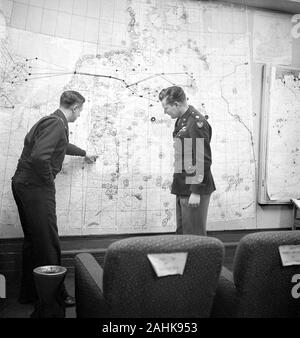 Deux officiers de l'armée d'étudier la carte en 8e siège de l'Armée de l'air, peut-être la salle des opérations à l'extérieur de Londres, en Angleterre pendant la Seconde Guerre mondiale, photo de Toni Frissell, Janvier 1945 Banque D'Images