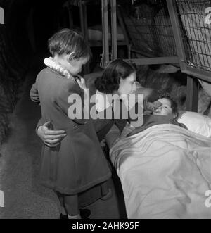 Femme avec deux enfants, un en double, en Tunnel souterrain pendant la Seconde Guerre mondiale, les bombardements de Londres, Angleterre, Royaume-Uni, photo de Toni Frissell, Janvier 1945 Banque D'Images