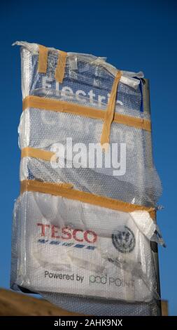 Un signe d'un nouveau chargement podpoint voiture électrique à un magasin Tesco dans Greenfield,Oldham,UK. L'podpoint n'est pas encore prêt à l'emploi, donc bubblewrapped. Banque D'Images