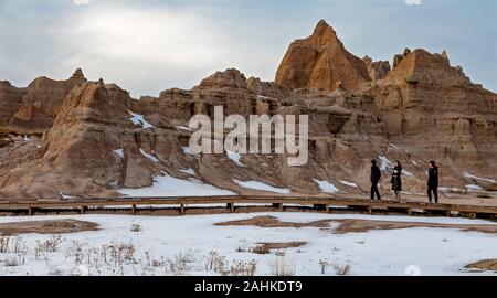 Badlands National Park en hiver. Les visiteurs sur une promenade, une partie de l'exposition de fossiles Trail. Banque D'Images