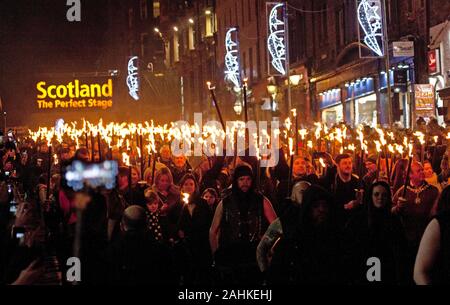 Edinburgh, Ecosse, Royaume-Uni. 30 décembre 2019. Procession aux flambeaux marquant le début de la nouvelle année de célébrations fait son chemin vers le bas du Royal Mile d'Édimbourg Lord Provost Frank Ross et Willie Rennie leader libéral démocrate écossais sont dans le groupe de tête, avec Pipe & Bandes de tambour et l'Ecosse Celtic Fire Theatre company, PyroCeltica, et le signe avant-coureur de l'équipe du tambour. Credit : Arch Blanc/ Alamy Live News. Banque D'Images