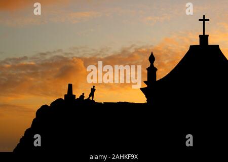 Chapelle avec silhouette de personnes au coucher du soleil. Contre-jour. Leça Da Palmeira, Porto, Portugal. Banque D'Images