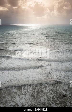 Au cours des vagues de vent marin avec un temps orageux et spectaculaire coucher de soleil sur la côte rocheuse d'Aphrodite Rock a Paphos, Chypre Banque D'Images