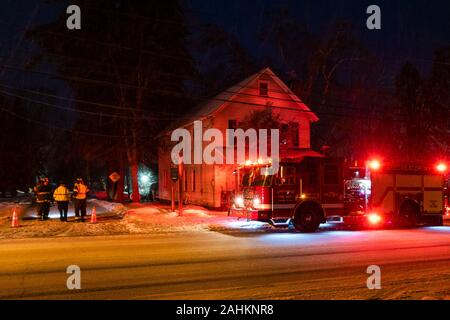 Un camion à incendie et les pompiers répondant à une tempête de neige d'endommager les fils électriques dans la région de spéculateur, NY USA sur une froide nuit d'hiver. Banque D'Images