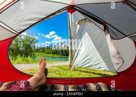La première personne de l'intérieur d'une tente de camping d'un paysage luxuriant et les Rocheuses en Alberta, Canada, avec copie espace à droite Banque D'Images
