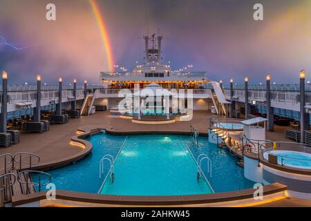 La terrasse de la piscine de l'crujise avec navire Norwegian Jade.arc-en-ciel et de la foudre. Banque D'Images