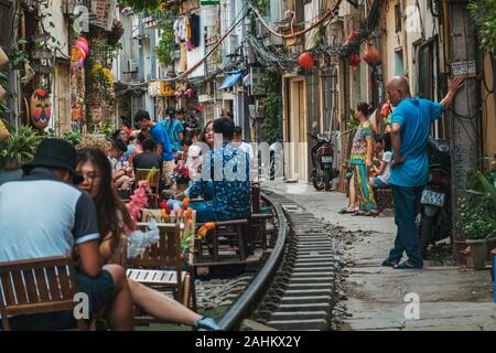 Les touristes profiter de cafés en plein air sur les pistes dans le fameux train Hanoi Street, ONG 224 Le Duan, dans le Vieux Quartier Banque D'Images