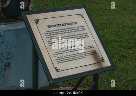 Une plaque commémorative à côté d'un Mikoyan-Gourevitch MiG-21 Izdeliye 94 interceptor jet, exposé au Musée de l'air de Hanoi, Vietnam Banque D'Images