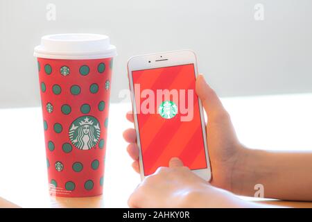Calgary (Alberta). Canada 28 Déc 2019. Une personne titulaire d'un iPhone à l'aide de l'application Starbucks avec un café au cours de Noël. Starbucks a employé congédié Banque D'Images