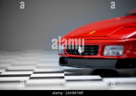 Izmir, Turquie - le 27 décembre 2019. Jouet rouge Ferrari voiture de sport 348to close up image du produit sur un sol à damiers et fond gris. Banque D'Images