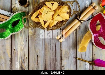 Traditionnel Pourim avec hamantaschen cookies, crécelle et masque de carnaval sur fond sombre Banque D'Images