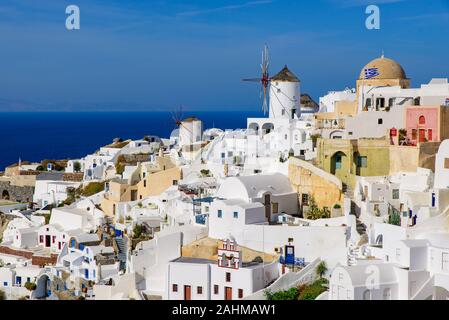 Moulin blanc traditionnel et immeubles faisant face à la mer Méditerranée à Oia, Santorin, Grèce Banque D'Images