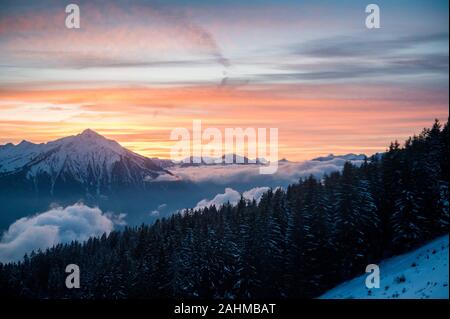 Coucher du soleil d'hiver coloré avec le Mont Niesen, les nuages et la forêt Banque D'Images