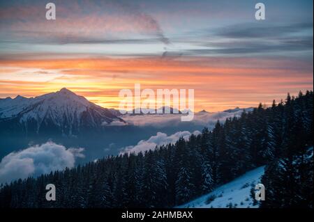 Coucher du soleil d'hiver coloré avec le Mont Niesen, les nuages et la forêt Banque D'Images