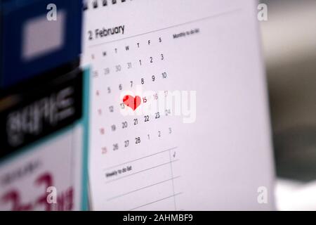 Gros plan d'une page du calendrier 24 février Saint-valentin où le 14ème est marqué par un cœur rouge irrégulière marque. Banque D'Images