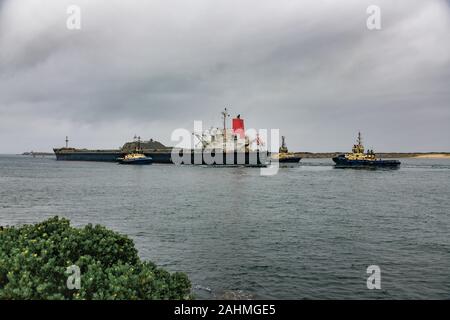 Transport en vrac du charbon avec des remorqueurs de quitter le port de Newcastle (Australie) Banque D'Images