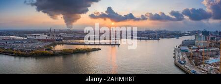 Drone aérien vue panoramique du port de Hambourg pendant le coucher du soleil avec de la fumée et des nuages sur les activités de la grue de chantier naval Banque D'Images