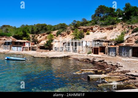 Une vue sur la crique de Cala Tarida Ibiza Island, en Espagne, en soulignant les abris de pêcheurs traditionnels Banque D'Images