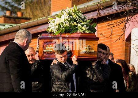 Les porteurs portent le cercueil de poignardée Joseph (Joe) Dutton à la suite d'une messe de requiem à St Oliver Plunkett's Church dans l'ouest de Belfast. M. Dutton, 47, et Frances Murray, 37 ans, est mort après avoir été poignardé dans un appartement à Kinnaird Fermer dans le nord de la ville le 22 décembre. Un homme a été arrêté et accusé de la double meurtre. Banque D'Images