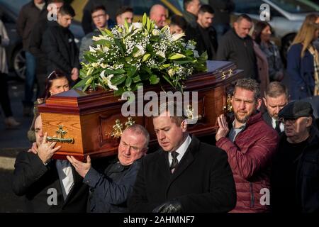 Les porteurs portent le cercueil de poignardée Joseph (Joe) Dutton à la suite d'une messe de requiem à St Oliver Plunkett's Church dans l'ouest de Belfast. M. Dutton, 47, et Frances Murray, 37 ans, est mort après avoir été poignardé dans un appartement à Kinnaird Fermer dans le nord de la ville le 22 décembre. Un homme a été arrêté et accusé de la double meurtre. Banque D'Images