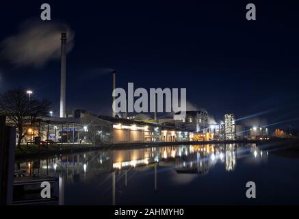 L'usine de betterave à sucre Cantley travaillant dans les heures sombres, les bâtiments reflètent dans la rivière Yare, Norfolk Banque D'Images