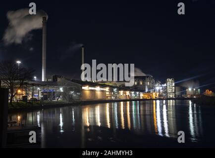 L'usine de betterave à sucre Cantley travaillant dans les heures sombres, les bâtiments reflètent dans la rivière Yare, Norfolk Banque D'Images